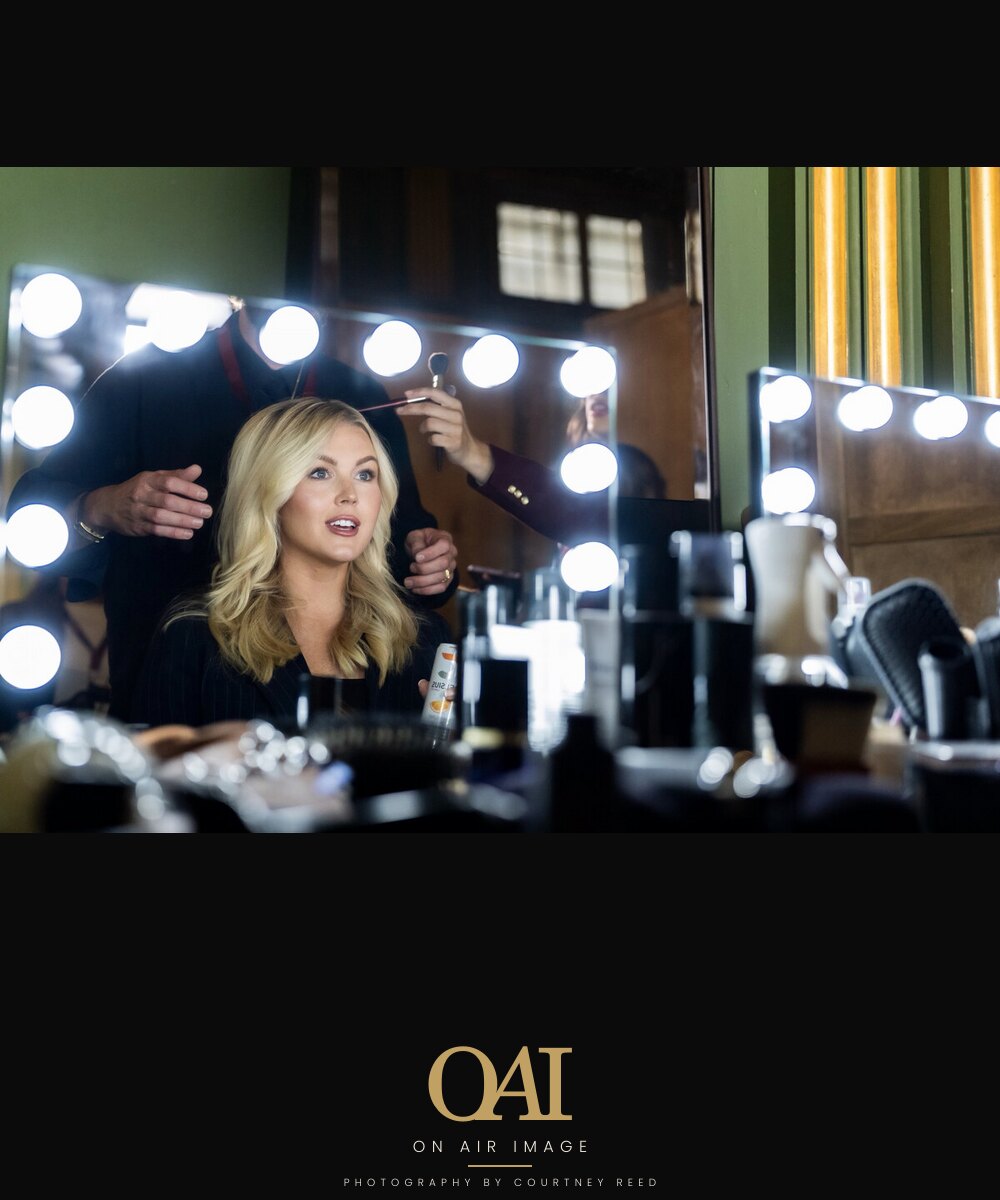 Final hair and makeup check at the mirror before air